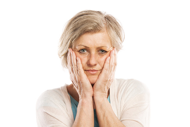 Senior woman suffering from toothache, isolated on white background